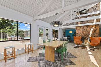 A room with a table and chairs and a ceiling fan.